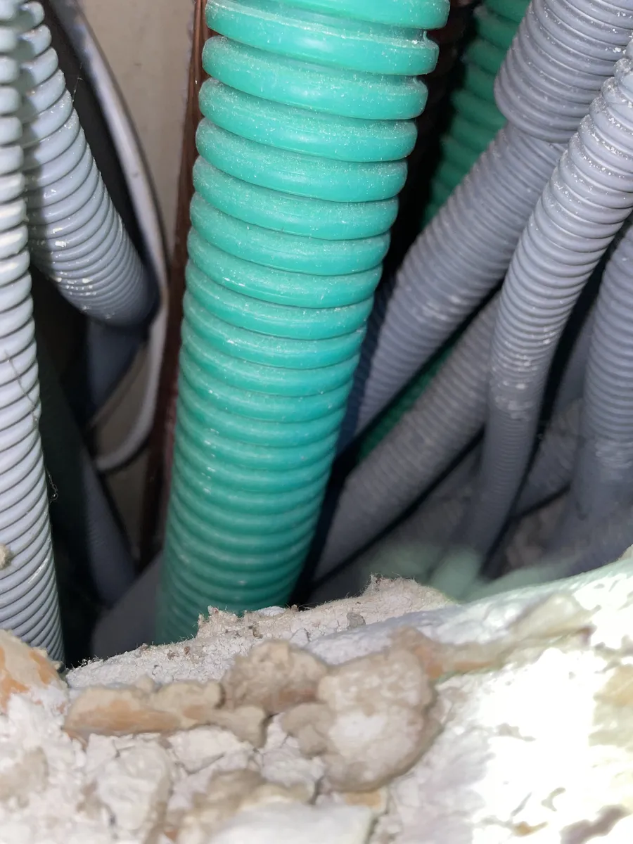 Gaines ICTA de plusieurs couleurs passées dans une saignée avant rebouchage, sur un chantier à Montpellier