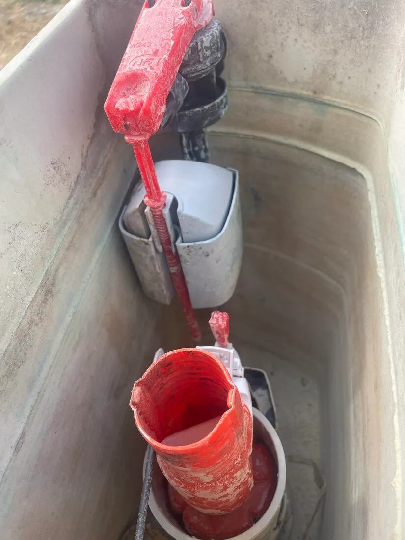 Mécanisme de chasse d'eau entartré : le calcaire bloque la fermeture du clapet et laisse fuir la cuvette