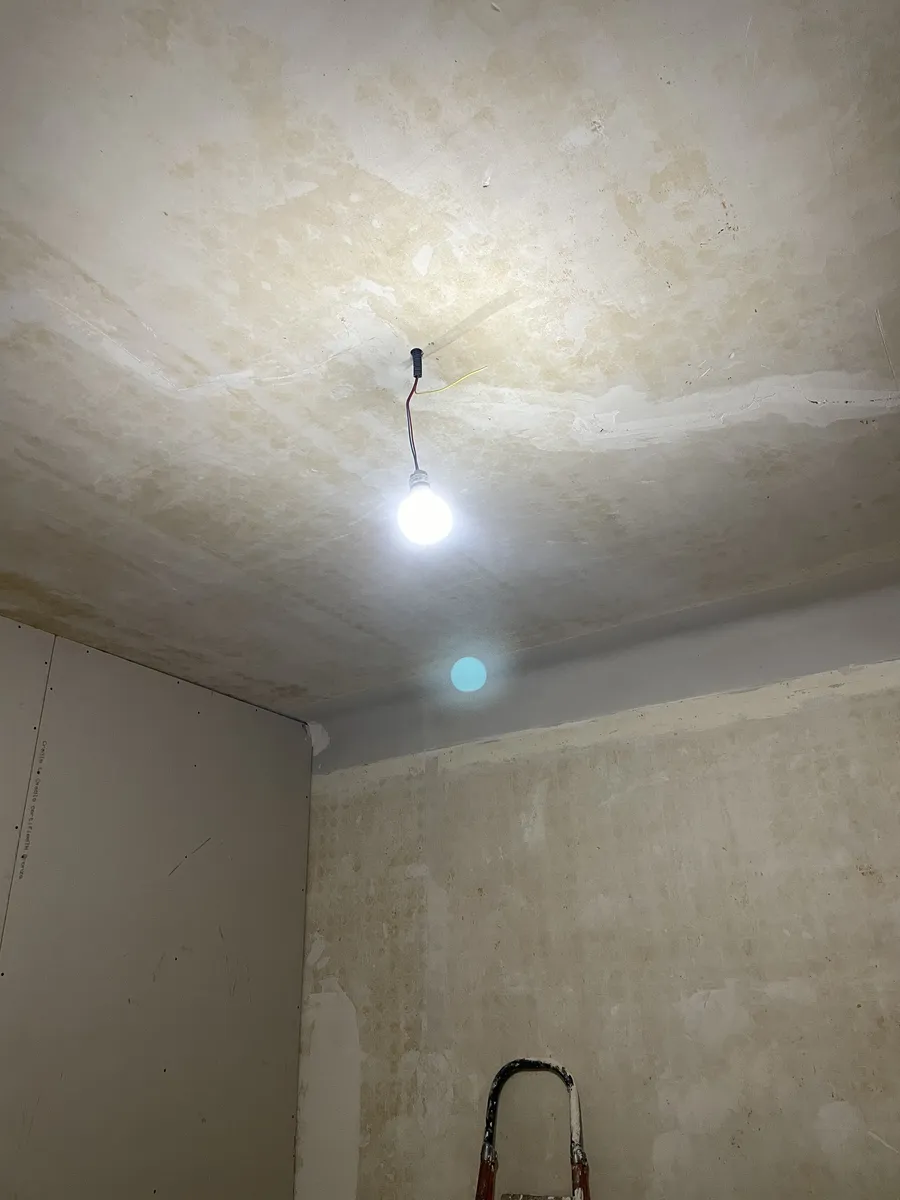 Pièce en cours de préparation avant peinture à Montpellier : plafond repris à l'enduit par zones, murs mis à nu, cloison en plaque de plâtre neuve et escabeau